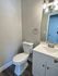 Elegant bathroom featuring a modern white vanity, sleek toilet, and stylish lighting.
