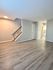 Bright living space with modern laminate flooring and an elegant staircase.