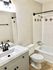 Elegant bathroom with a modern vanity, stylish lighting, and decorative tile accents.