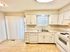 Bright and elegant kitchen with white cabinetry, modern appliances, and hardwood flooring.