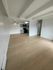 Modern apartment interior with open-concept living and dining area featuring sleek hardwood floors and a contemporary kitchen.