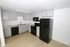 Modern kitchen with sleek black appliances and elegant gray cabinetry.