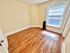 Bright, cozy room with polished wood flooring, large window, and classic radiator, perfect for a creative space in your new home.