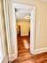 Bright and inviting entryway with warm wooden floors leading into a cozy room with soft lighting.