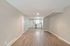 Bright and modern open-concept living space featuring sleek hardwood floors, neutral walls, and a contemporary kitchen.