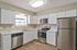 Modern kitchen with sleek stainless steel appliances, elegant white cabinetry, and spacious countertops.