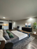 Luxurious open-concept studio apartment with modern decor, featuring a spacious bed, sleek kitchenette, and stylish living area with a large TV.