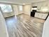 Bright open-concept space featuring modern kitchen with sleek cabinetry, stylish flooring, and abundant natural light.