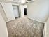 Bright and inviting bedroom with plush carpet, ceiling fan, and spacious closet in a modern apartment.