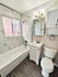 Modern bathroom featuring sleek marble tiles, a bright vanity, and stylish fixtures.