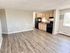Inviting open-concept kitchen and living area with modern appliances and sleek hardwood flooring.