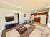 Bright and inviting open-concept living space featuring a cozy seating area, modern kitchen with wooden cabinets, and stylish dining nook.