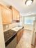 Charming kitchen featuring elegant dark granite countertops, warm wood cabinetry, and bright natural light.