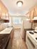 Charming kitchen with granite countertops, ample wooden cabinets, and natural light from a large window.