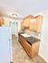 Cozy kitchen with natural wood cabinets, granite countertops, and modern appliances, offering a warm and inviting cooking space.
