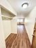 Bright hallway with elegant hardwood flooring, built-in closet, and a large window allowing natural light.
