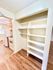 Bright kitchen with sleek wood cabinets, modern stove, and ample shelving for storage.