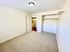 Bright and spacious bedroom featuring a built-in closet and soft carpeting, perfect for comfortable living.