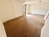 Bright and inviting living room with plush carpeting and natural light streaming through the door, ideal for relaxation.