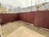 Charming private patio with wooden fencing, perfect for outdoor relaxation and gardening.