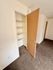 Cozy apartment interior featuring a closet with built-in shelving and plush carpet flooring.