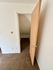 Cozy storage nook with beige carpet and neutral walls, featuring a classic wooden door.