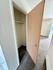 Inviting open closet with beige door, leading into a spacious carpeted room with natural light.