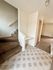Inviting interior entryway featuring a cozy carpeted staircase and a stylish tiled floor transitioning to plush carpet.