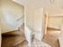 Inviting split-level apartment entrance featuring soft carpeted stairs and a bright, open hallway with stylish design.