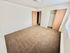 Bright and spacious bedroom with plush carpet, large window offering natural light, and a convenient built-in closet.