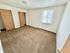 Bright, spacious bedroom with two large closets, beige carpeting, and a sunlit window creating a warm ambiance.