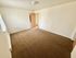 Spacious bedroom with plush carpet, natural light, and neutral walls for a cozy and inviting atmosphere.