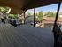 Spacious balcony with a scenic view of rooftops and lush green hills, offering a peaceful outdoor retreat.