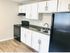 Modern kitchen with sleek black appliances, spacious countertops, and white cabinetry offering a clean, contemporary look.