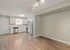 Modern open-concept kitchen with stainless steel appliances, sleek cabinetry, and elegant hardwood floors.