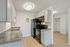 Modern kitchen with sleek granite countertops, elegant cabinets, and black appliances, offering a stylish and functional space.