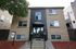 Modern apartment building with stylish entrance, framed by a clean landscape and inviting facade.