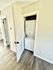 Modern apartment showcasing a convenient in-unit laundry with a sleek stacked washer and dryer behind a stylish louvered door.