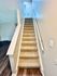 Inviting carpeted staircase leading to a bright and spacious upper floor, complemented by elegant wooden flooring and sophisticated wall textures.