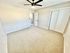 Bright and spacious bedroom featuring a modern ceiling fan, plush carpeting, and ample closet space.