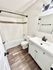 Elegant bathroom with modern vanity, sleek tile backsplash, and inviting bathtub in a bright, fresh setting.
