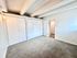 Bright and spacious bedroom with modern white closets and plush carpeting, offering a serene living space.