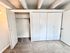 Spacious apartment closet with sliding doors and ample storage space, featuring modern design and cozy carpeted flooring.
