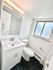 Bright, modern bathroom with hexagonal tile floor, sleek vanity, and large window for natural light.