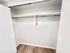 Spacious walk-in closet with sleek wooden flooring and ample hanging space.