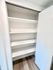 Spacious built-in closet with sleek white shelves and modern design.