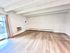 Spacious living room with modern wood flooring, natural light, and balcony access.