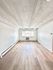 Bright and spacious room with modern wood flooring and large window inviting natural light.
