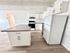 Bright, modern kitchen with sleek white cabinetry, spacious island, and contemporary appliances.
