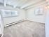 Bright and spacious empty room with large windows, plush carpet, and modern light fixture.